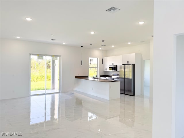 kitchen with pendant lighting, white cabinets, sink, and stainless steel appliances