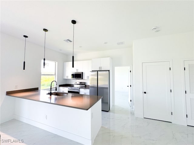 kitchen with white cabinets, kitchen peninsula, sink, pendant lighting, and appliances with stainless steel finishes