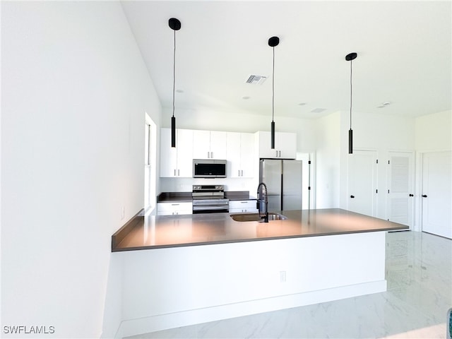 kitchen with white cabinets, appliances with stainless steel finishes, sink, and decorative light fixtures