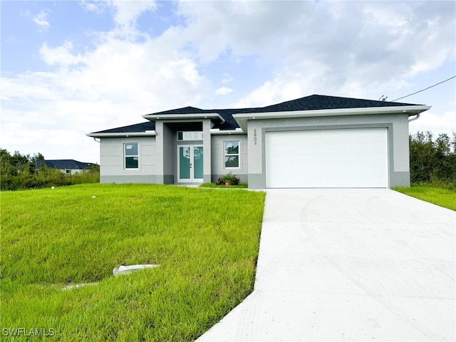 view of front of property featuring a front yard and a garage