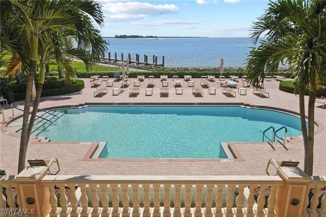 view of swimming pool featuring a patio and a water view