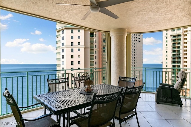 balcony with ceiling fan and a water view