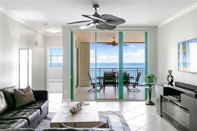 living room with a water view, crown molding, and light tile patterned flooring