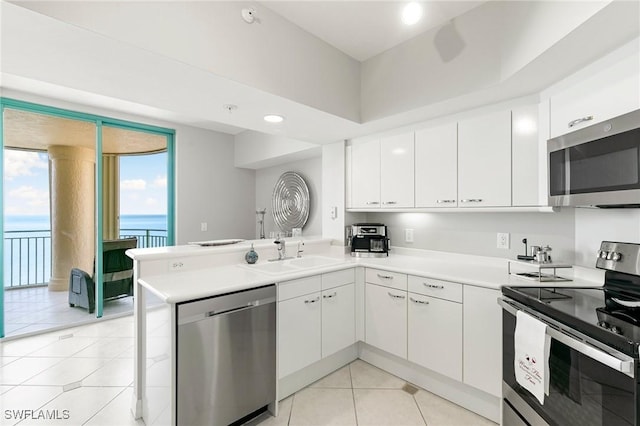 kitchen with kitchen peninsula, sink, white cabinets, and stainless steel appliances