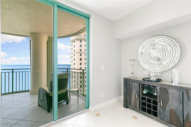 bar with a water view and light tile patterned flooring