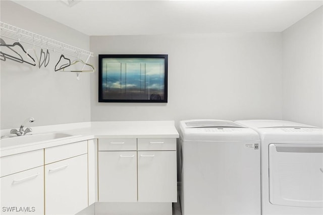 laundry room with cabinets, independent washer and dryer, and sink