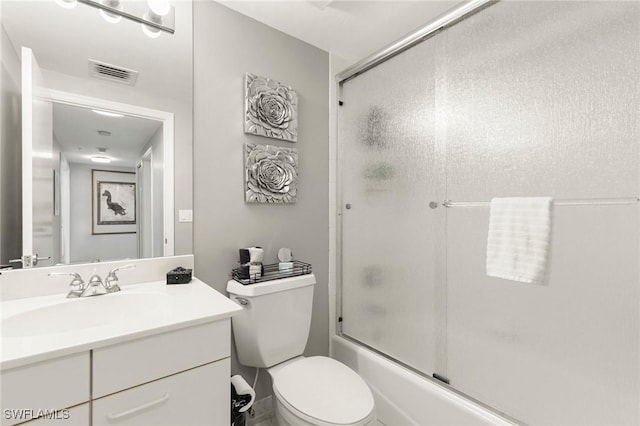 full bathroom featuring vanity, bath / shower combo with glass door, and toilet