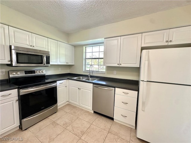 kitchen featuring sink, a textured ceiling, white cabinets, and appliances with stainless steel finishes