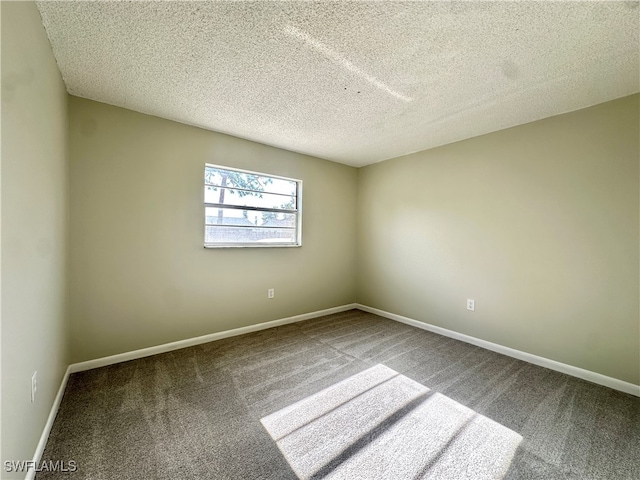 carpeted empty room featuring a textured ceiling