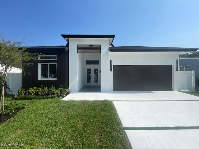 contemporary house featuring a front yard, french doors, and a garage