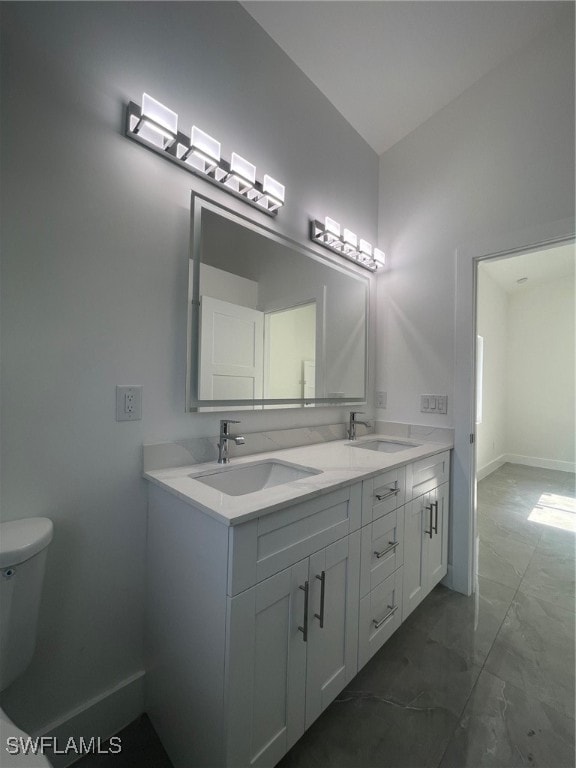 bathroom with double vanity, toilet, and tile patterned flooring