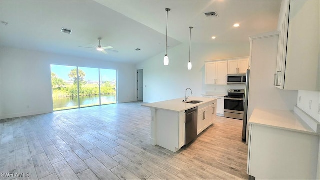 kitchen with white cabinets, stainless steel appliances, a kitchen island with sink, and ceiling fan