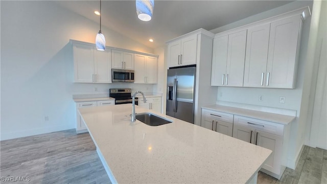 kitchen featuring stainless steel appliances, sink, decorative light fixtures, white cabinets, and lofted ceiling