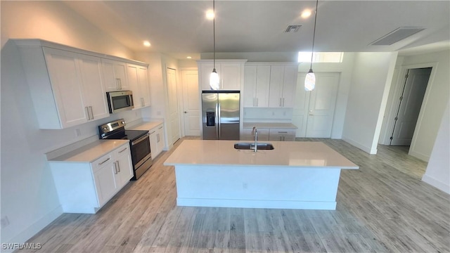 kitchen featuring a center island with sink, white cabinetry, sink, and appliances with stainless steel finishes