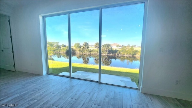 doorway to outside featuring a water view and light hardwood / wood-style floors