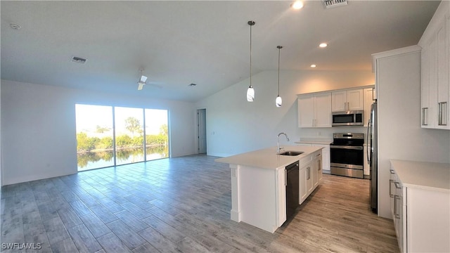 kitchen with white cabinets, a kitchen island with sink, sink, and appliances with stainless steel finishes