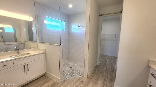 bathroom featuring tiled shower, hardwood / wood-style floors, and vanity