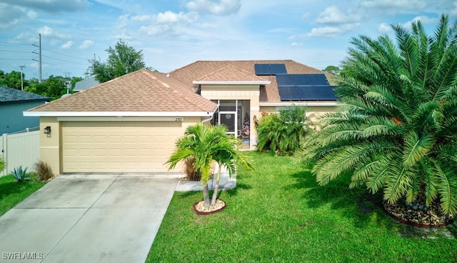 view of front facade with a front yard, solar panels, and a garage