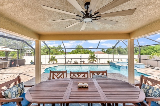 view of swimming pool featuring glass enclosure, a patio, an in ground hot tub, and ceiling fan