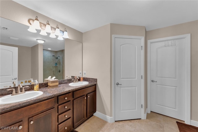 bathroom featuring dual vanity, tiled shower, and tile patterned flooring