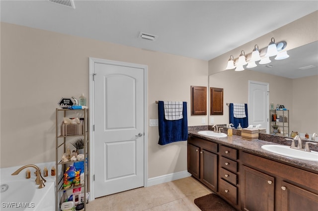 bathroom with a tub, double vanity, and tile patterned flooring