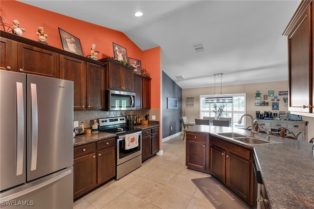 kitchen featuring appliances with stainless steel finishes, light tile patterned floors, vaulted ceiling, tasteful backsplash, and sink