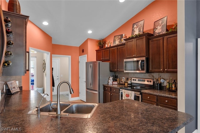 kitchen with stainless steel appliances, dark brown cabinets, vaulted ceiling, backsplash, and sink