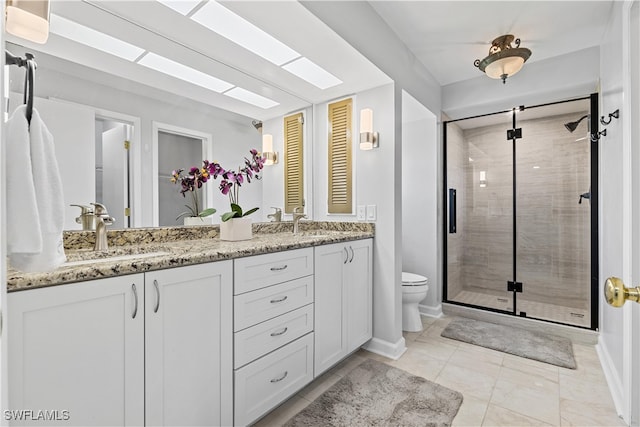 bathroom featuring tile patterned flooring, toilet, dual bowl vanity, and an enclosed shower