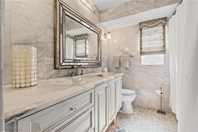 bathroom featuring tile patterned floors, toilet, tile walls, and vanity