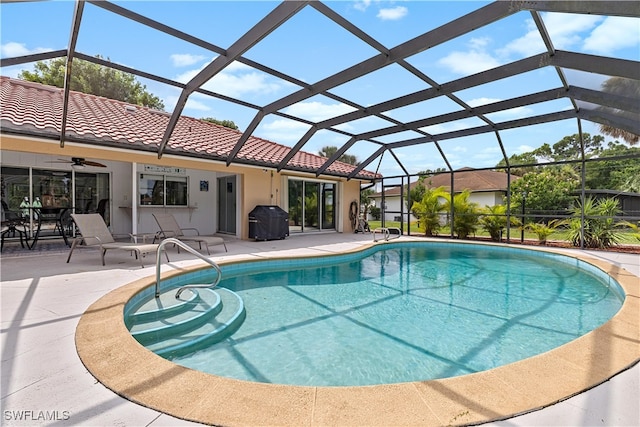 view of swimming pool featuring ceiling fan, a patio, and a lanai