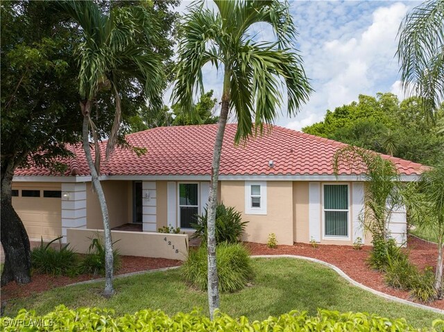 ranch-style home with a front lawn and a garage