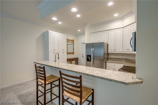 kitchen featuring white cabinetry, stainless steel appliances, a breakfast bar, and kitchen peninsula