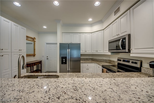 kitchen featuring ornamental molding, sink, appliances with stainless steel finishes, and white cabinetry