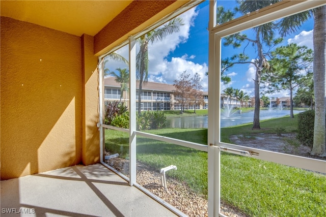 unfurnished sunroom featuring a water view