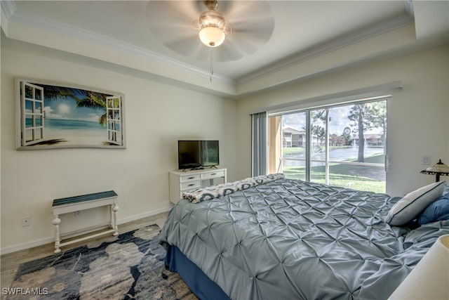 bedroom featuring a raised ceiling, access to exterior, hardwood / wood-style floors, ceiling fan, and ornamental molding