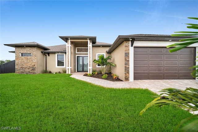 prairie-style house featuring a front lawn and a garage