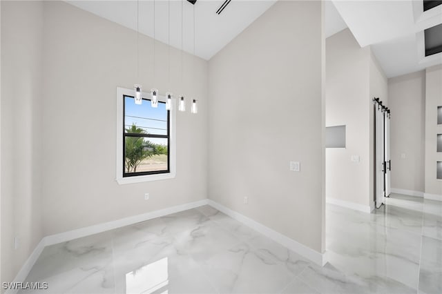 spare room with a barn door, high vaulted ceiling, and tile patterned floors