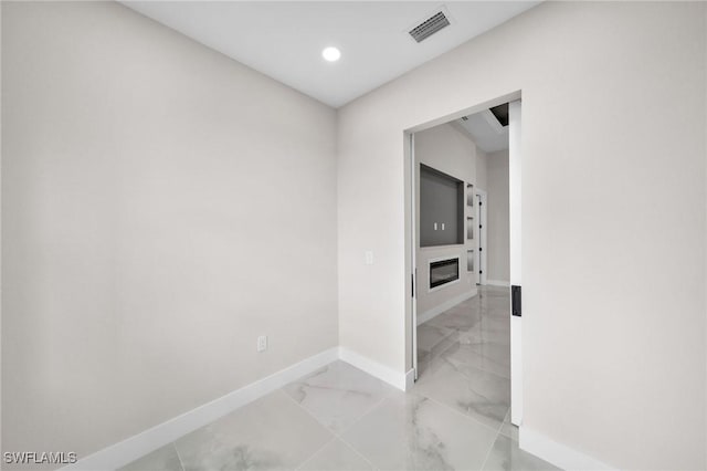 hallway featuring marble finish floor, baseboards, visible vents, and recessed lighting