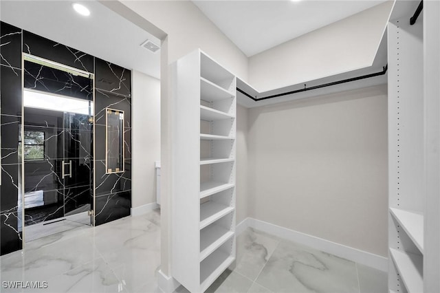 walk in closet with marble finish floor