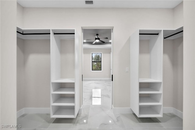 spacious closet featuring marble finish floor, visible vents, and a ceiling fan