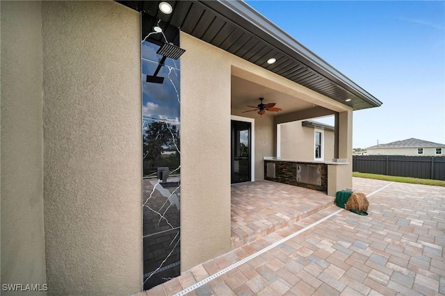 view of patio featuring ceiling fan, area for grilling, and fence