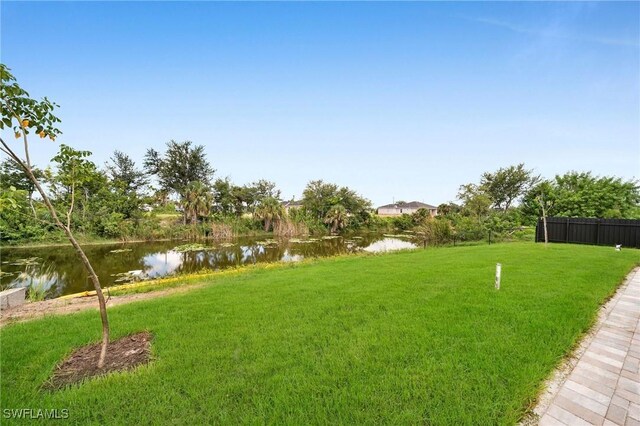 view of yard featuring a water view and fence