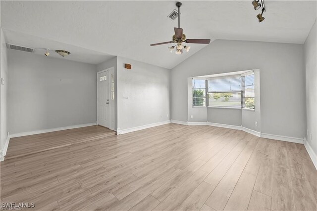 unfurnished room featuring ceiling fan, light hardwood / wood-style floors, rail lighting, and vaulted ceiling