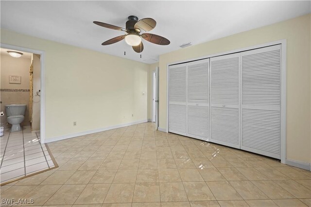 unfurnished bedroom with ceiling fan, a closet, connected bathroom, and light tile patterned floors