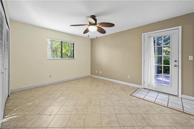 spare room with ceiling fan and light tile patterned flooring