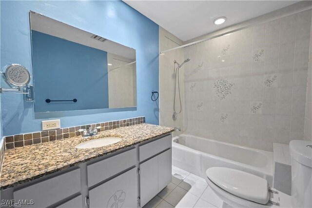 full bathroom featuring decorative backsplash, toilet, vanity, tile patterned floors, and tiled shower / bath