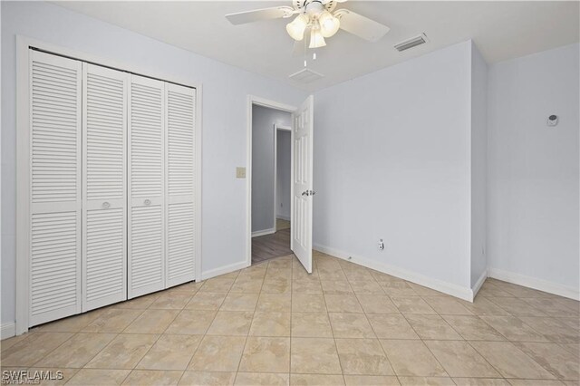 unfurnished bedroom with a closet, ceiling fan, and light tile patterned floors