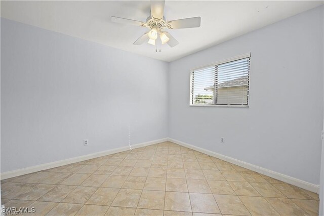 tiled spare room with ceiling fan