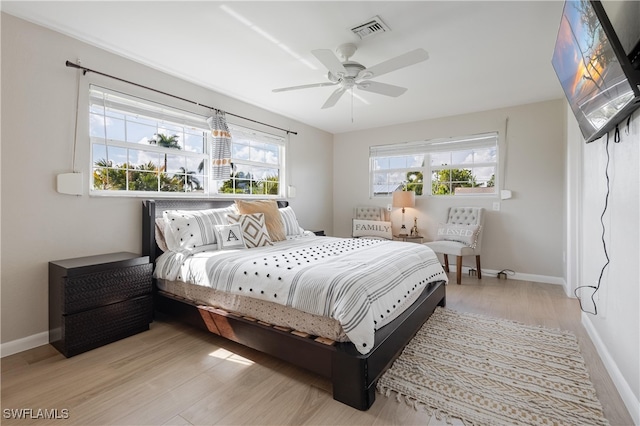 bedroom featuring multiple windows, ceiling fan, and light wood-type flooring