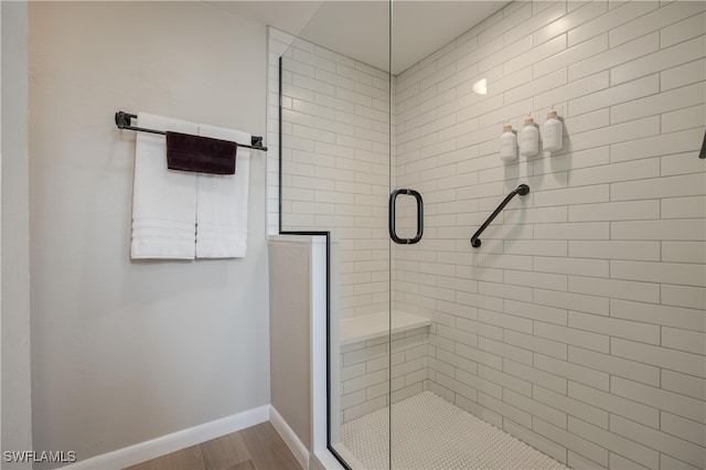 bathroom with wood-type flooring and an enclosed shower